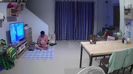 Father leaps with fright when snake emerges next to him while watching TV