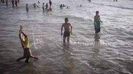 Palestinian children playing sports jumping in the water on the beach in Deir al-Balah central Gaza Strip.