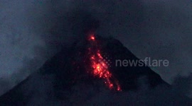 Lava flows out of Mayon Volcano's crater as slow eruption continues