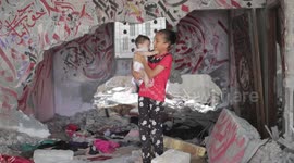 Palestinian artist draws calligraphy artwork on ruins of house destroyed by Israeli airstrikes