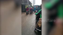Motorcycle rider loses balance in sudden flash flood in Indonesia