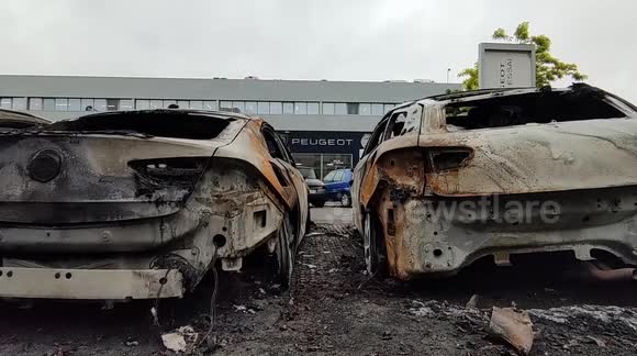 France unrest: Burnt-out cars at a Peugeot car dealership in Paris suburb of Bondy