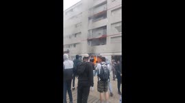 A building burns in Nanterre, after violent clashes. Young people from the city climb to alert the inhabitants, despite the risks.