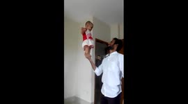 Man balances baby on his hand
