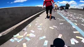Drivers scramble to collect bundles of cash when 72,000 DOLLARS worth of notes fly from security guards backpack