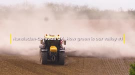 Cornwall Heatwave. Farm tractor kicks up huge dust clouds whilst spreading crushed limestone soil acidity reducer. Nansledan Valley Newquay Cornwall UK