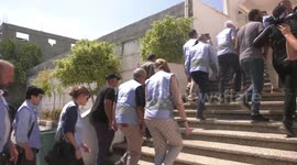 Members of an international envoys delegation look at rubble during a tour of the Jenin camp for Palestinian refugees in the West Bank