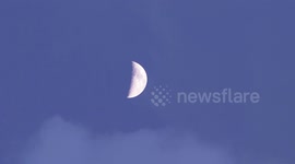 Light Clouds Blow Past and Evening Moon In a Clear Dusk Sky