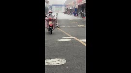 Unique rainfall pattern sends Chinese scooter riders scrambling for shelter