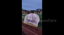 Elderly man packs cool mat and mosquito net for relaxing evening in playground