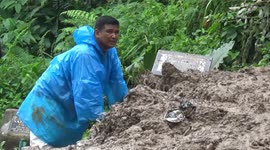 Dozens of graves unburied as landslides and floods hit cemetery in Padang, Indonesia