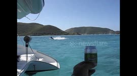 Kiteboarder grabs a beer while sailing past me in the BVI