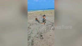 Cute little boy enjoys mud-playing with his pet dog