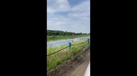 Wakeboarder glides across river whilst pulled by car in INCREDIBLE stunt