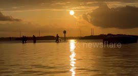 Net Fisherman Return at Sunset Past Derelict.Boat