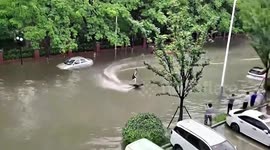 Chinese man transforms flash flood commute into incredible urban surfing experience