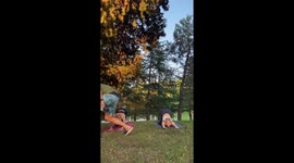 Playful corgi interrupts ladies' yoga session in public park
