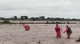 Rescue operation officials rescue senior citizen stuck in water owing to heavy floods in western India
