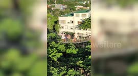 Girl with acrophobia bravely crosses wobbly rope bridge
