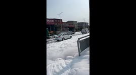 Detergent factory overflows creating surreal snowy streetscape in central China