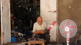 A Palestinian man Mustafa Abdo, repairs fan at his shop amid a heatwave at Shati refugee camp in Gaza City