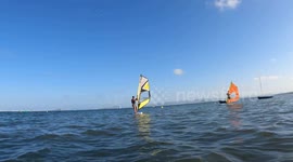 Windsurfer sailing towards camera crashes and falls down
