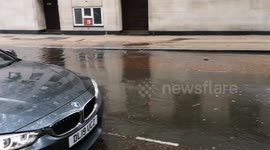 Heavy rain in London causes one of the roads on London's Southbank to flood over causing a bit of worry for car owners