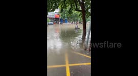 Elderly man rides a tricycle as rainstorm Hits Beijing, China
