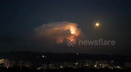 Storm cloud illuminated by lightning looms over southwest China