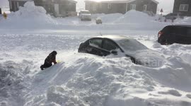Kids climbing in a huge snow drift higher than a parked car during Arctic blizzard