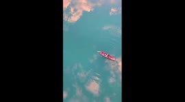 Rosy sunrise clouds mirrored by tranquil waters