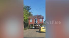 Entire house blocks drivers while being transported on tractor in Cambodia