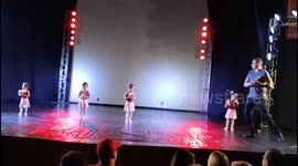Loving dad helps shy daughter with ballet steps on stage