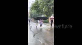 A Man Holding a Huge Umbrella in the Rain in Beijing, China