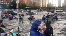 Vehicles navigate roads submerged in deep floodwater in China
