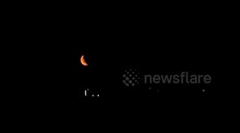 Beautiful red crescent moon seen rising over horizon in East London