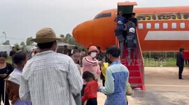 Excited locals take pictures outside airplane-shaped building at park