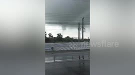 Dozens of home damaged when waterspout tornado tears through seaside village in the Philippines