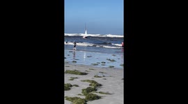 Beachgoers Work to Rescue Boat