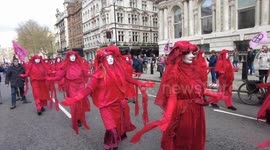 Red-robed Extinction Rebellion Satanist activists symbolising the blood of the children