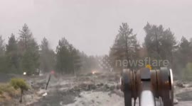 Mudflows from Tropical Storm Hilary surge over road in California