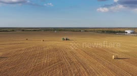 A hay bailer works fields in west Texas.