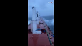 Challenging waves from the Atlantic Ocean breach the deck of cargo ship