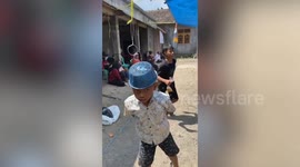 Youngster battles to insert hook through hole in amusing party game in Indonesia