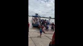Disaster at Mekong River ferry crossing at Tan Chau in Vietnam where the overloaded scooter comes to grief when driving off the ferry.