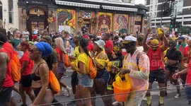 Revellers spray themselves with paint and powder during Notting Hill Carnival 2023