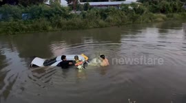 Driver rescued from half-submerged car in canal 'after dozing off at the wheel' in Thailand