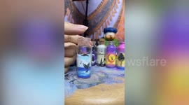 Artist pours sand into tiny glass bottle to make awesome beach scene