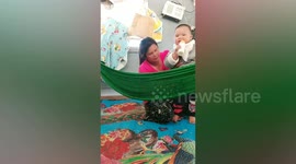 Mother hilariously struggles to put chubby baby in hammock