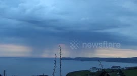 A view of the Rain clouds over Tintagel filmed from across Port isaac Bay.